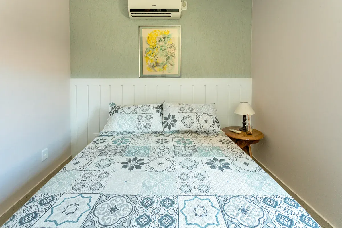 Quarto de casal com colcha azul e branca