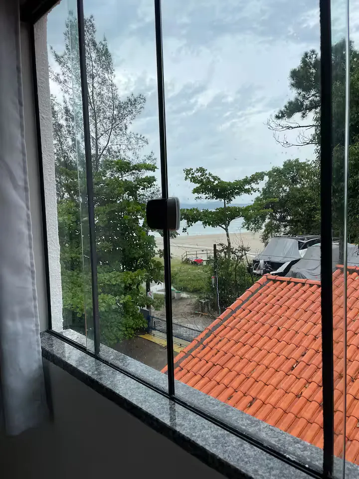 Vista da janela, com as árvores e o mar ao fundo