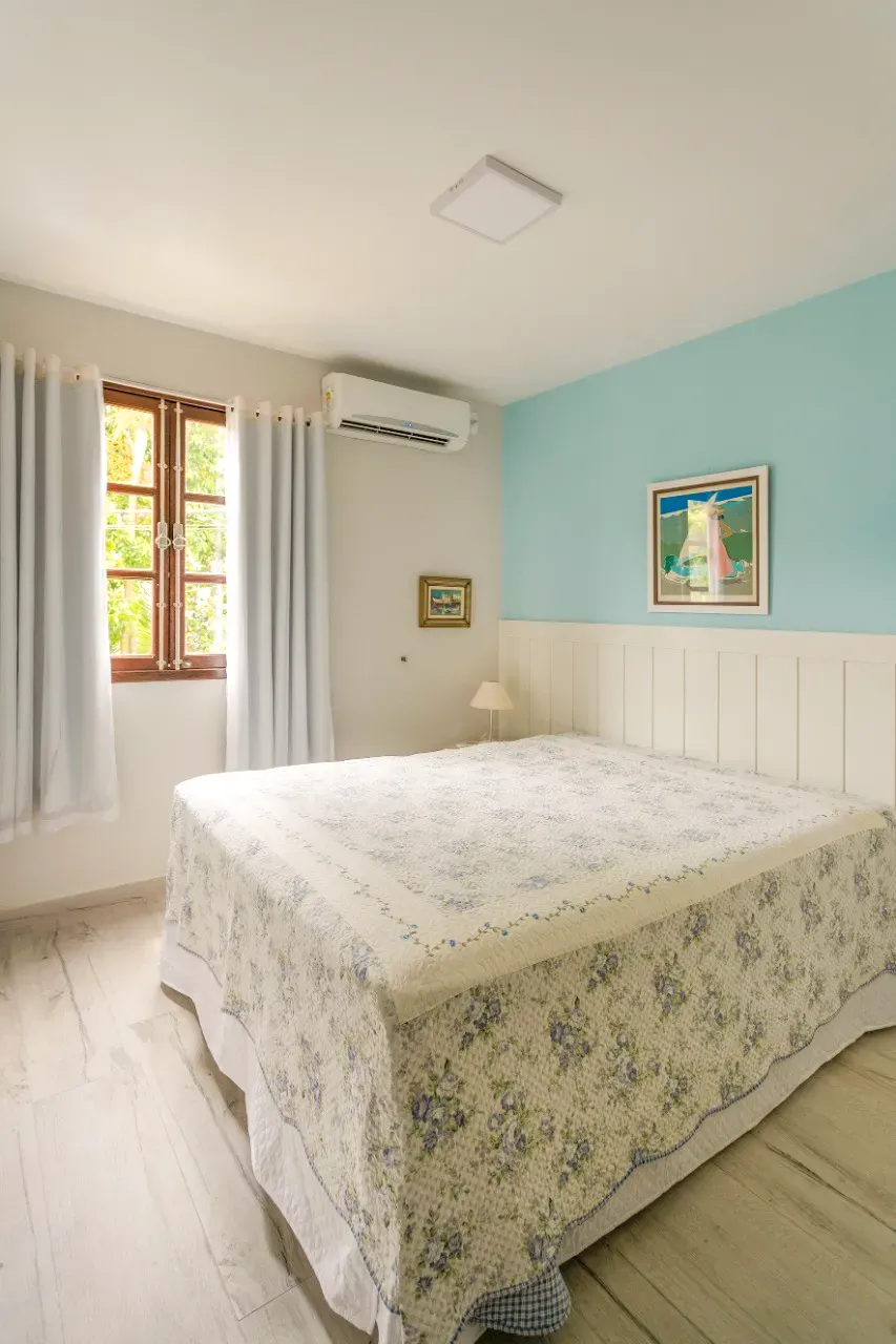 Quarto de casal com parede azul e ar-condicionado