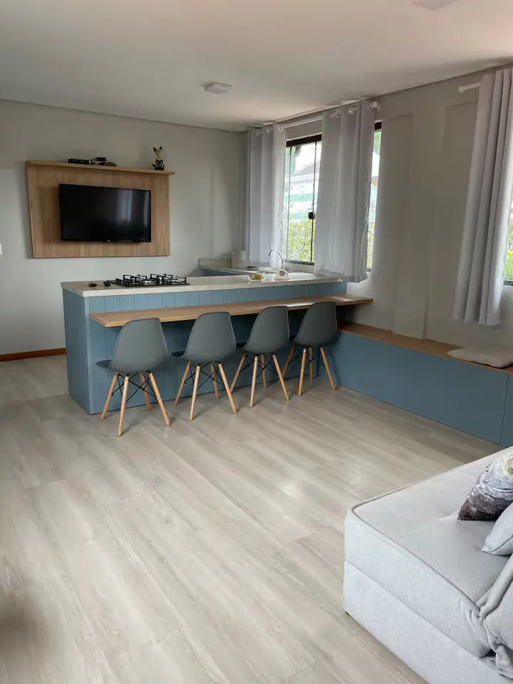 Sala integrada à cozinha, com TV