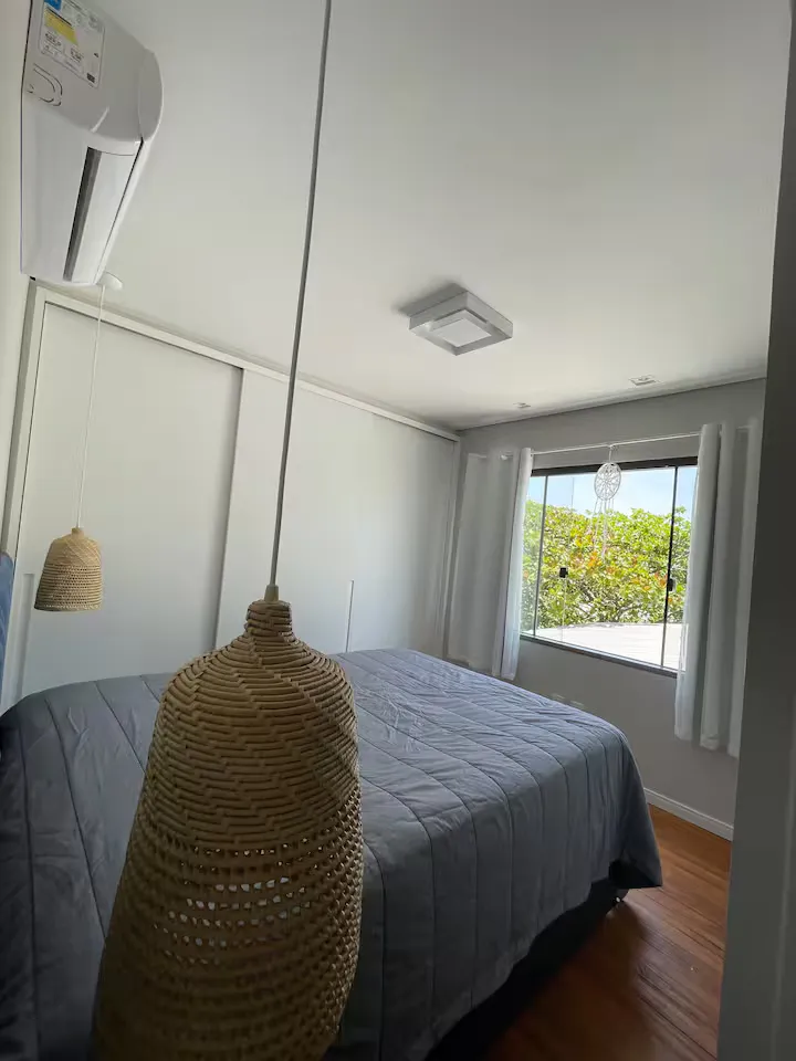 Quarto com luminária de palha e janela