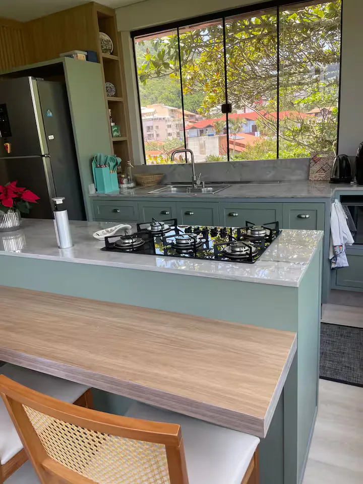Cozinha com cooktop e vista para o verde