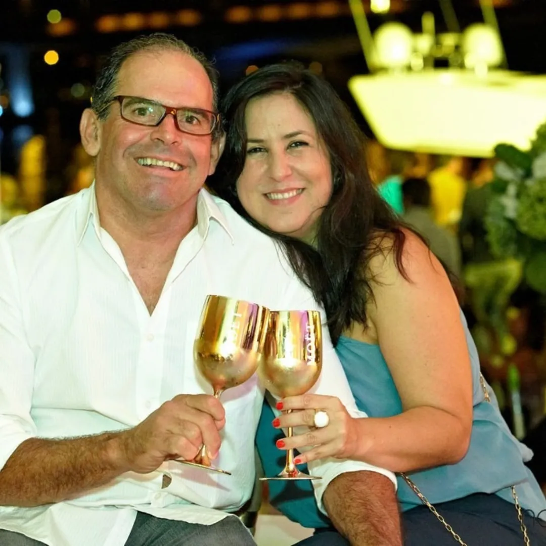 Marcelo e Carla sorrindo e brindando