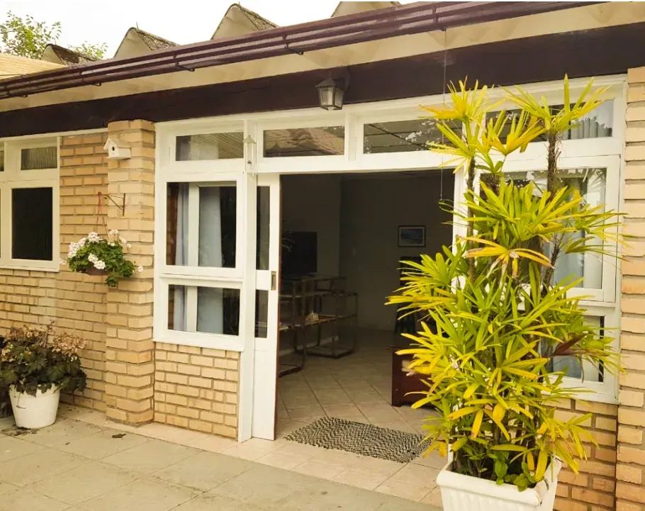 Entrada do estúdio, com portas de vidro e plantas